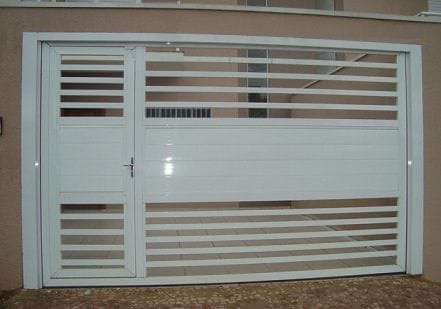 Portão metálico branco de garagem com porta social integrada