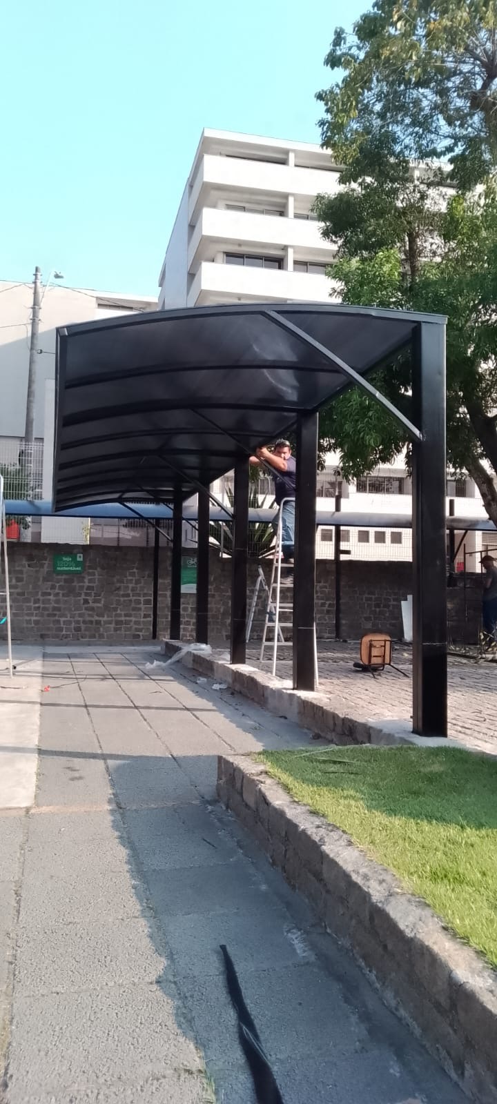 Cobertura metálica curva sendo montada em área externa