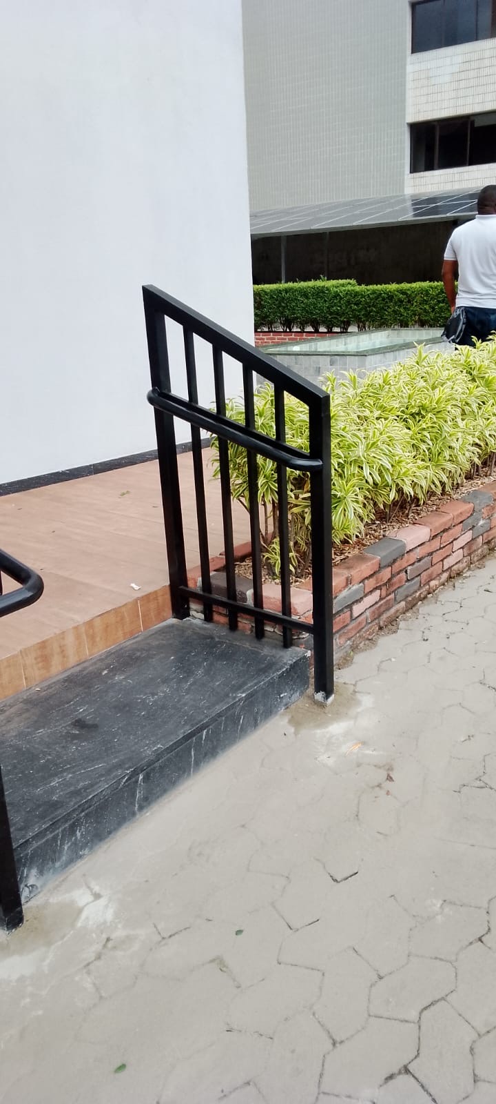 Guarda-corpo metálico instalado entre calçada e jardim